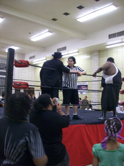 Mr. WOOD talks with the ref while LUCIFER enters the ring.