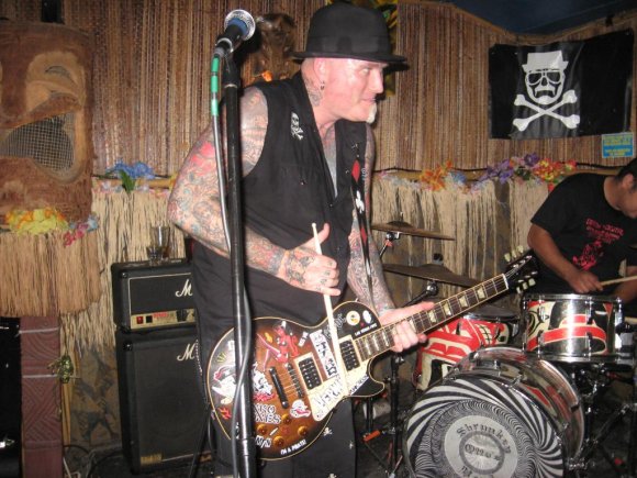 DIRK sometimes uses a drumstick to play the guitar.