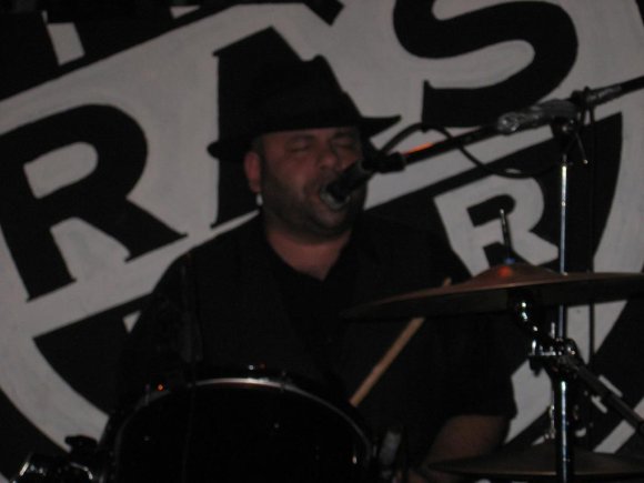 SWAMI sings while playing the drums.