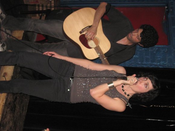 MEGHAN sings while OSCAR plays guitar.
