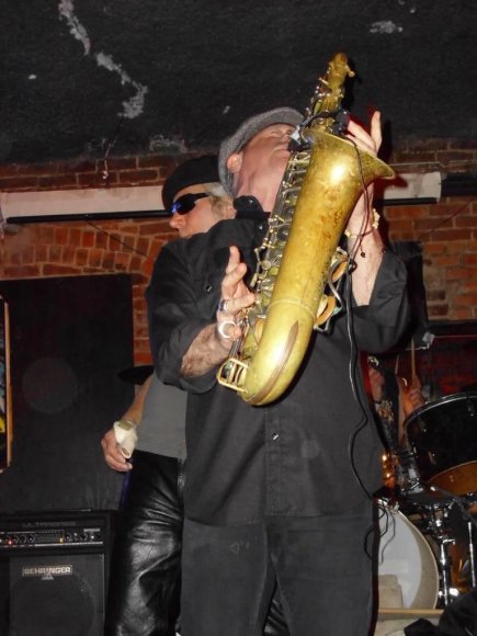 DANNY RAY wails away with JOHN hanging over his shoulder.