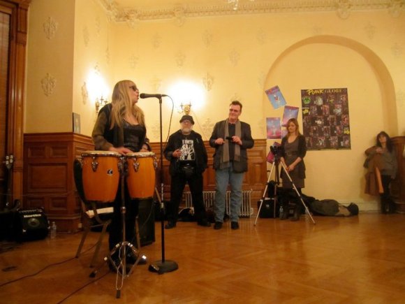 JOY RYDER plays the congas while FRANK WOOD and JOE KELLY watch.